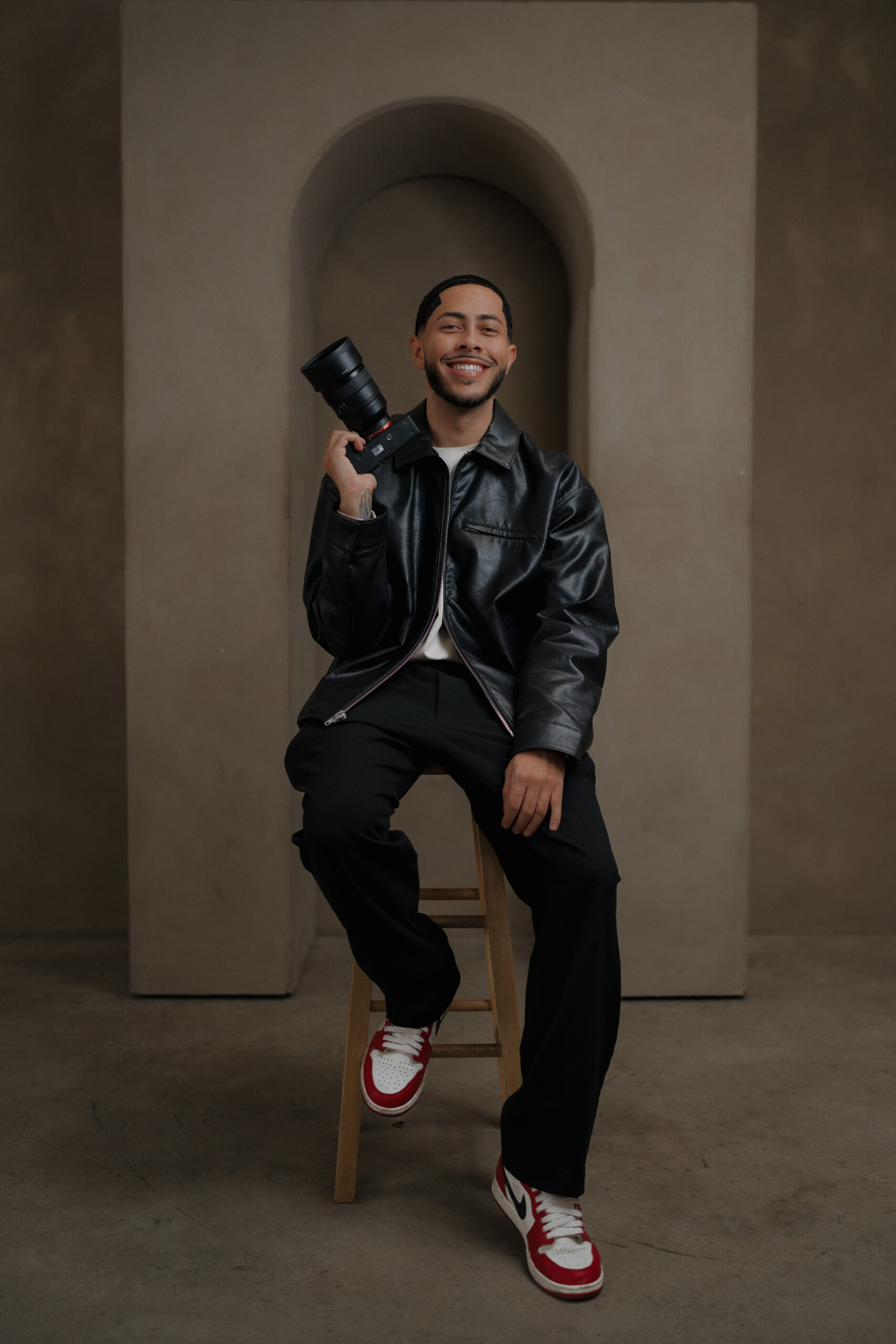 Las Vegas wedding photographer Jalen Moore holding a camera during a portrait session for Moore Focus Photography